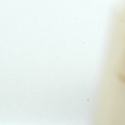 A closeup video of a man stamping on white paper, leaving the impression of line art of a nude Baba Yaga, grinning and riding her flying mortar and pestle, with a broom in hand.