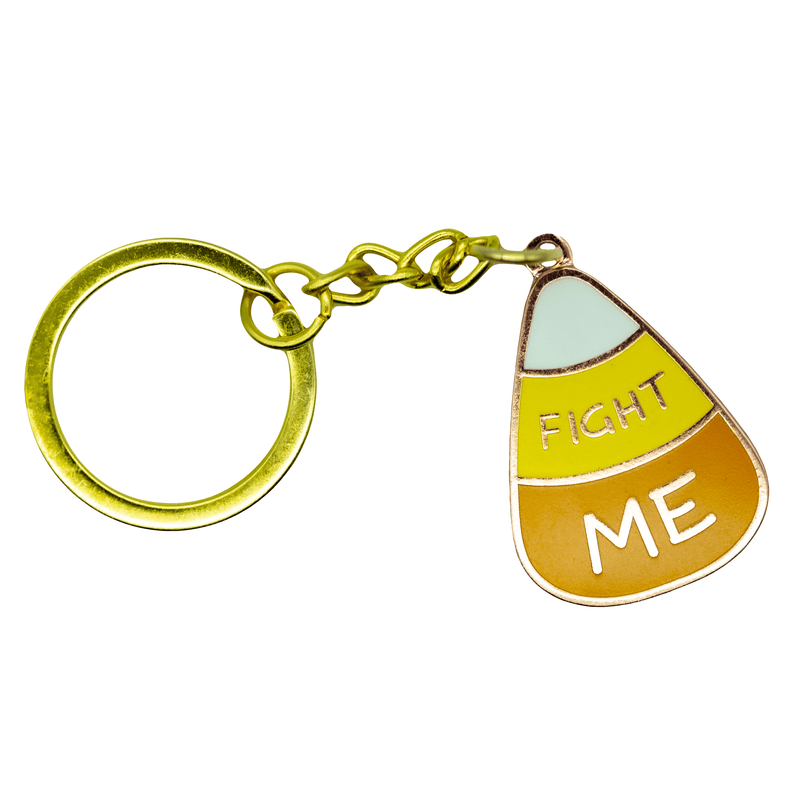 A cartoonish candy corn enamel charm on a keychain. The candy corn has "FIGHT ME" written on it.