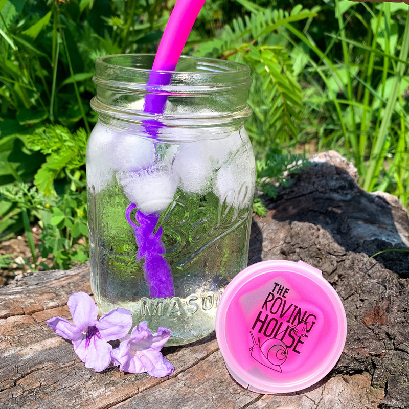 A neon pink silicone straw changing to purple in an ice cold beverage.