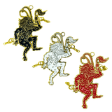 Three Krampus gold plated enamel ornaments in black, white, and red.