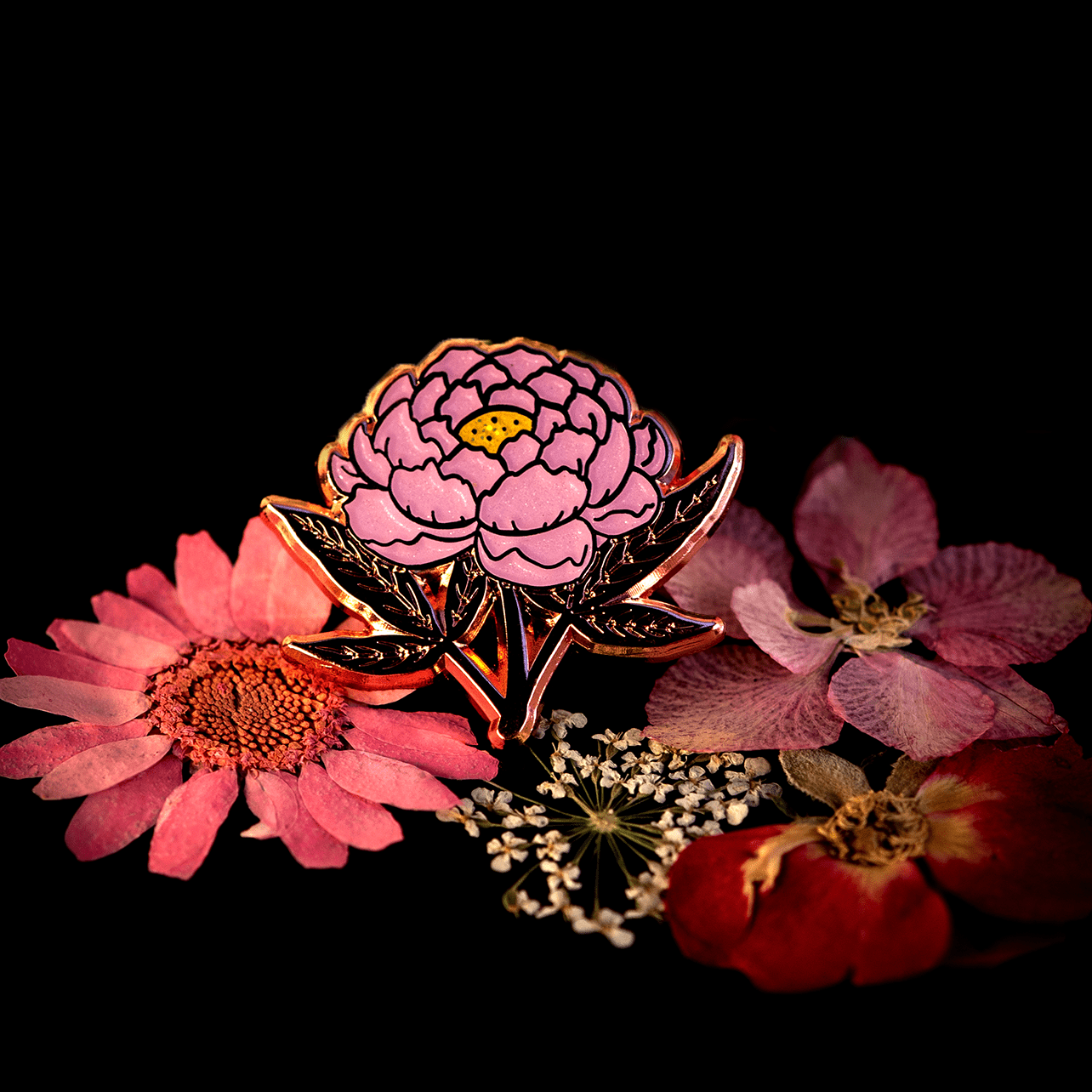 A pink peony hard enamel pin by The Roving House.