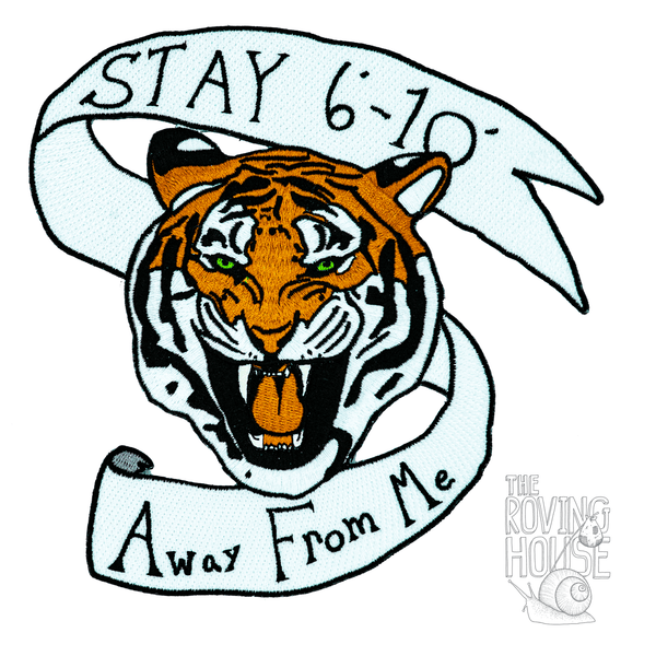A large, embroidered patch featuring the head of a snarling tiger, surrounded by a banner that says "STAY 6' - 10' Away From Me".